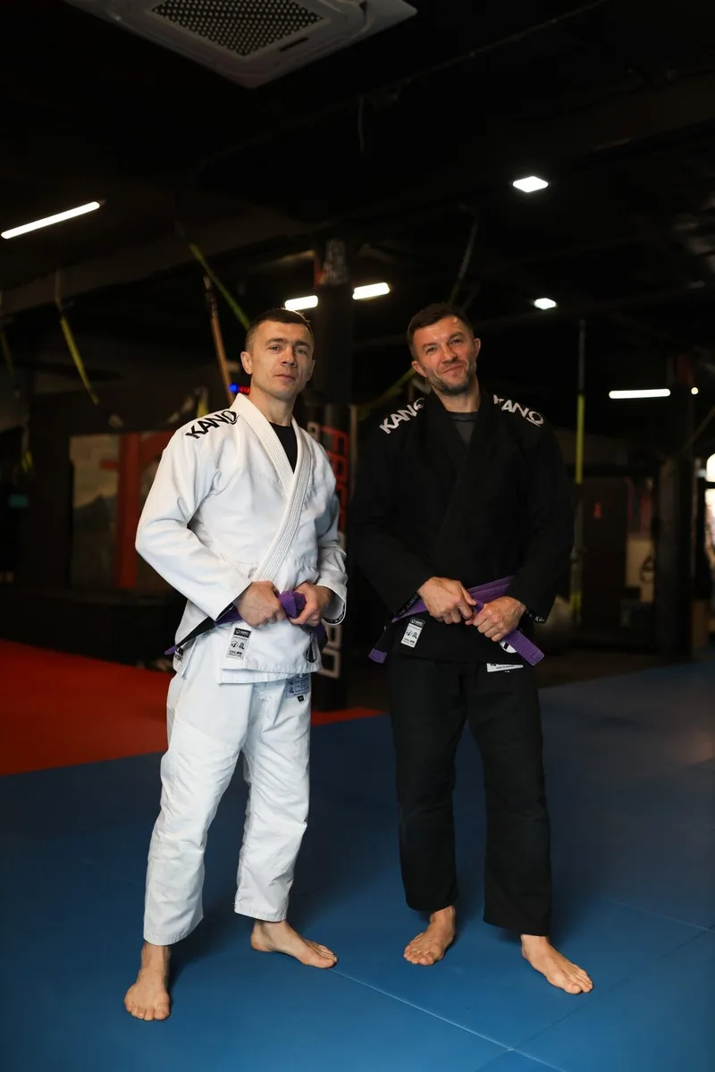 Dwóch dorosłych zawodników BJJ w gi podczas treningu